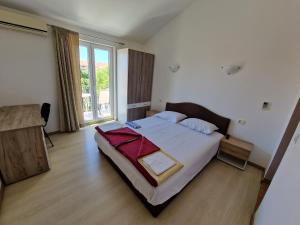 ein Schlafzimmer mit einem großen Bett und einem großen Fenster in der Unterkunft Guest House Damjana in Budva