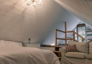 a bedroom with a bed and a couch and a chandelier at Verzasca Lodge Carlotta in Frasco