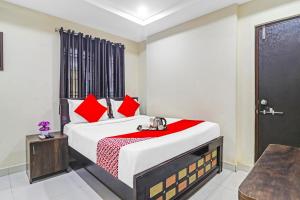 a bedroom with a large bed with red pillows at Super Hotel O Honey Heights Near Botanical Garden in Kondapur +47 photos