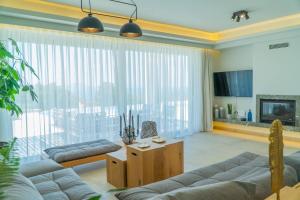 - un salon avec un canapé et une grande fenêtre dans l'établissement Carpe Diem Villa - Luxurious, 15km From The Beach, à Vederoi