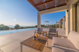 une terrasse avec une table, des chaises et une piscine dans l'établissement Carpe Diem Villa - Luxurious, 15km From The Beach, à Vederoi