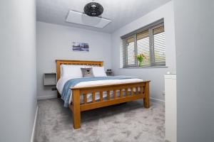 a bedroom with a wooden bed and a window at B’s house in Simpson