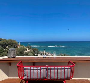 特拉維夫的住宿－TEL AVIV - Sea front Penthouse - 1604，红椅,坐在桌子前,戴着酒杯