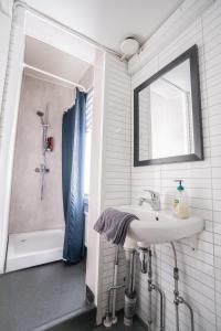 La salle de bains est pourvue d'un lavabo, d'une douche et d'un miroir. dans l'établissement Käytännöllinen huoneisto Pietarsaaressa, à Pietarsaari