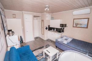 ein Wohnzimmer mit einem blauen Sofa und einer Küche in der Unterkunft Käytännöllinen huoneisto Pietarsaaressa in Pietarsaari