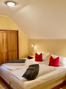 a bedroom with a large bed with red pillows at Schlosspension Ering in Ering