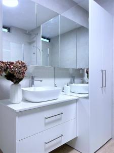 特拉維夫的住宿－TEL AVIV - Sea front Penthouse - 1604，白色的浴室设有两个盥洗盆和镜子
