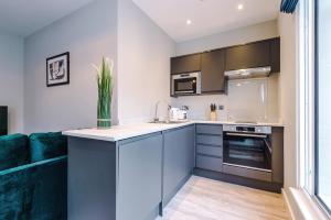 a kitchen with a blue couch and a kitchen counter at Stylish, Central and Spacious Apartments in Southport in Southport