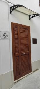 uma porta de madeira na lateral de um edifício em ARAS b&b - em Mazzarino