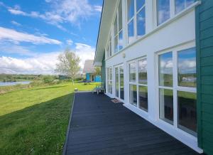 a house with a wooden walkway next to a building at Riverrun Holiday Homes No 15 in Belturbet