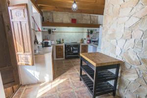 a kitchen with a table and a stone wall at Villa Los Leones Nerja in Nerja