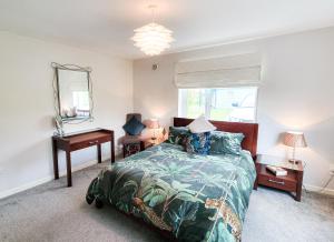 a bedroom with a bed and a desk and a mirror at Riverrun Holiday Homes No 15 in Belturbet
