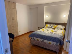 een kleine slaapkamer met een bed en een kast bij Hogarcito in Cuzco