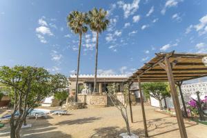 two palm trees in front of a building at Villa Los Leones Nerja in Nerja