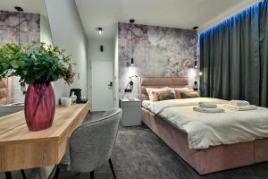 una camera con un grande letto e un tavolo con sedie di Rooms Florek & Florica a Križevci
