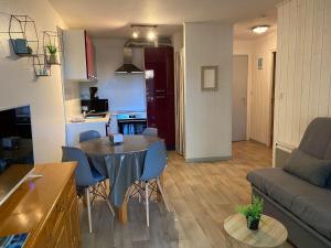 uma cozinha e uma sala de estar com mesa e cadeiras em Appartement T2 à 900m du Bassin d Arcachon em Arès
