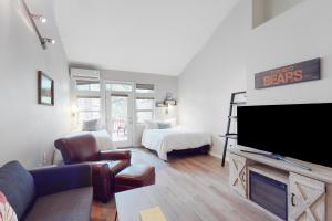 a living room with a flat screen tv and a bedroom at Seventh Mountain Studio in Bend