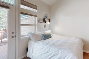 a white bed in a room with a window at Seventh Mountain Studio in Bend