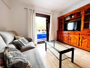 ein Wohnzimmer mit einem Sofa und einem TV in der Unterkunft Book It Casona Apartment Moraira in Moraira