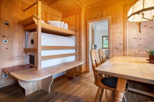 a wooden cabin with a table and a dining room at Valentin36 Apartment Geisler in Funes
