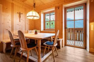 Valentin36 Apartment Geisler في فونيس: غرفة طعام مع طاولة وكراسي خشبية
