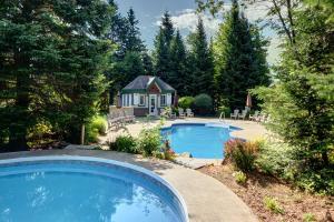 a swimming pool in a yard with a house at The Mont-Tremblant Hideaway by InstantSuites in Mont-Tremblant