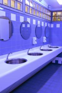 une rangée de quatre lavabos dans les toilettes publiques dans l'établissement The ESN Kingsday Campsite, à Amsterdam