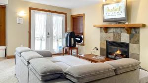 un salon avec un canapé et une cheminée dans l'établissement The Mont-Tremblant Hideaway by InstantSuites, à Mont-Tremblant