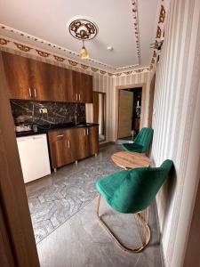une chambre avec deux chaises vertes et une cuisine dans l'établissement fafsuitehome, à Istanbul