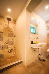 uma casa de banho com um lavatório e um chuveiro em SUITES DREAM TELENDOS em Telendos