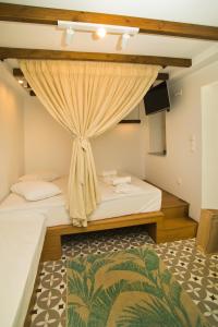 a bedroom with two beds and a curtain at SUITES DREAM TELENDOS in Kalymnos