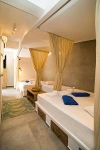 a hotel room with two beds and curtains at SUITES DREAM TELENDOS in Kalymnos