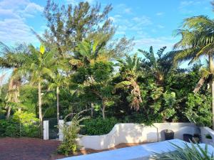 una cerca blanca frente a algunas palmeras en Villa Roc Guesthouse - Solar Power en Ballito