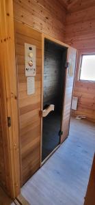 een deur in een houten kamer met een raam bij Wellness Bungalow Uppsala in Gramsbergen