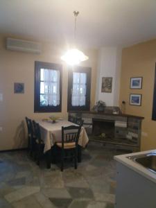 comedor con mesa, sillas y fregadero en Dimosthenis Karastamatis Rooms, en Xorychti