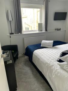 ein Schlafzimmer mit einem großen Bett und einem Fenster in der Unterkunft Little Limetree in Moffat