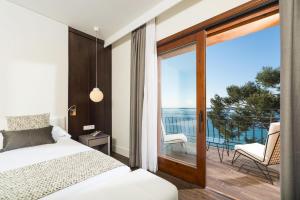 a bedroom with a bed and a balcony with a view at Hotel Santa Marta in Lloret de Mar