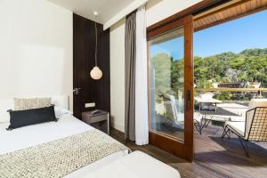 a bedroom with a bed and a balcony with a view at Hotel Santa Marta in Lloret de Mar
