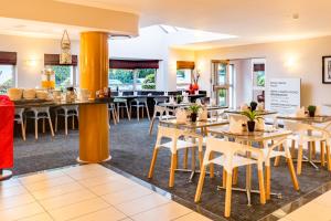 a dining room with tables and chairs in a restaurant at Road Lodge JNB Airport in Johannesburg