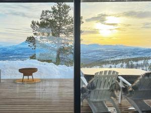 Moen i MålselvにあるHoliday home Moenのバルコニー(テーブル、デッキの椅子2脚付)