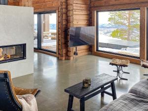 a living room with a fireplace and a tv at Holiday home Moen in Moen i Målselv