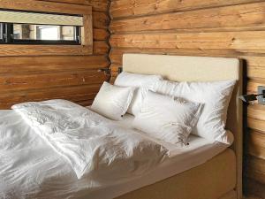 una cama con almohadas blancas en una habitación en Holiday home Moen, en Moen i Målselv