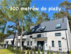 een wit huis met de woorden morrow do play bij La Brisa Apartments in Dziwnówek