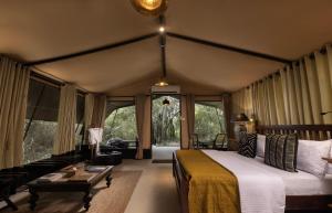 a bedroom with a bed in a room with windows at Leopard Trails Wilpattu in Wilpattu