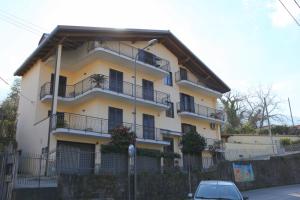 un edificio amarillo con balcones y un coche aparcado delante en Sofis Home, en Pimonte