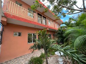 a orange building with a balcony and some trees at posada cándita in Tizimín