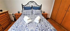 a bedroom with a bed with two white shoes on it at Apartamento Peonia 1 in Canet de Berenguer