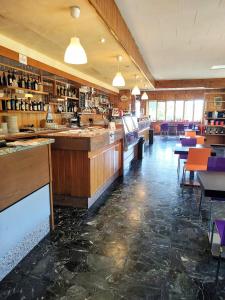 een restaurant met een bar en tafels en stoelen bij Hotel Ristorante Miramonti in Consuma