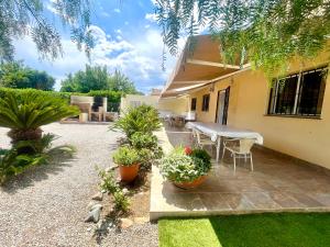Un patio con mesa y sillas y plantas. en Mas de la Maria, en Cambrils