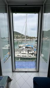 una finestra con vista su una barca nel porto turistico di Rd Guest house a Ischia
